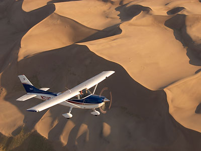 Plane flying over sand dunes